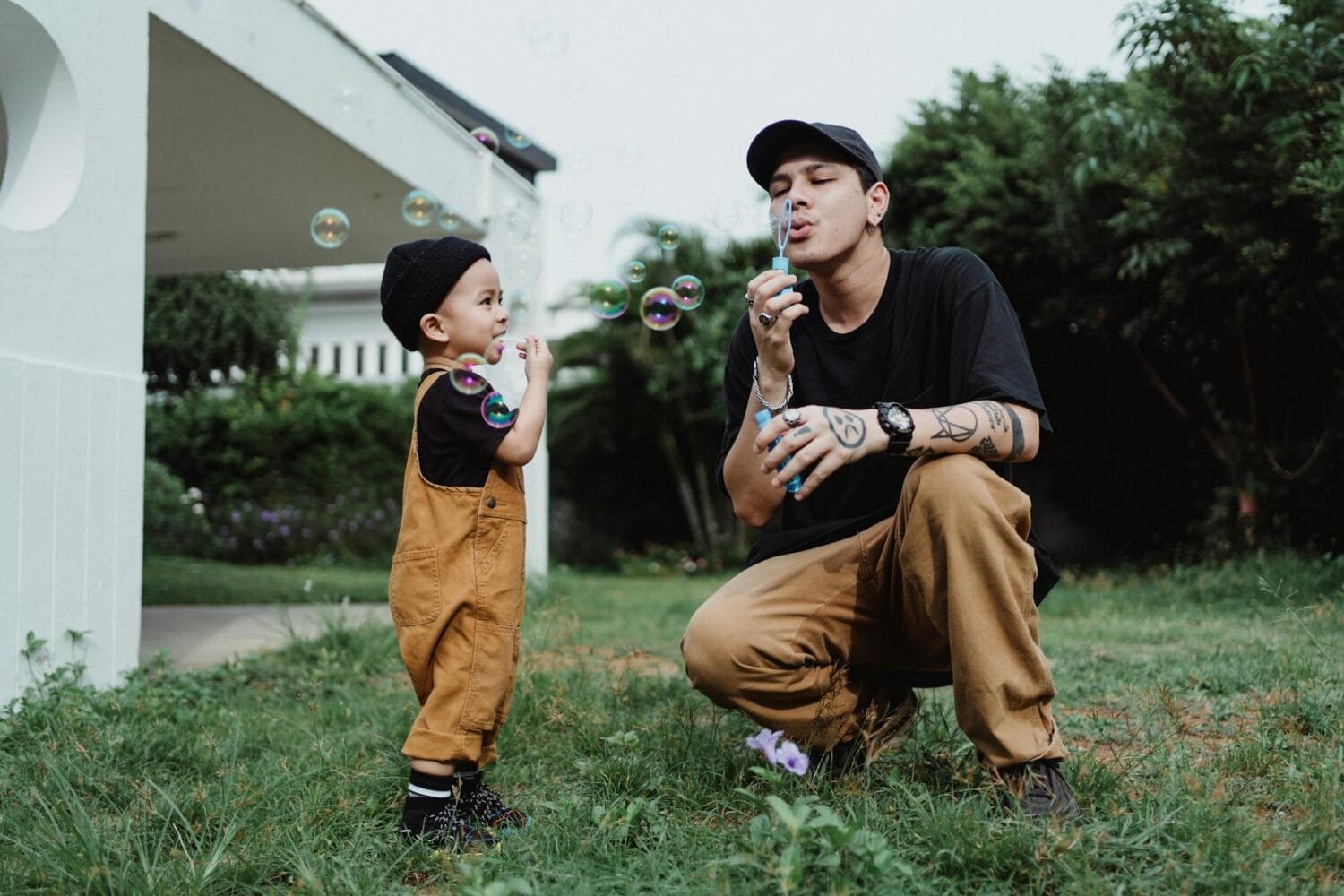father and son blowing bubbles together