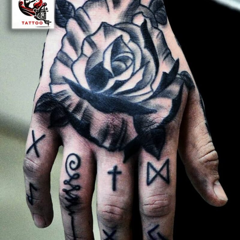 La mano adornada con una rosa neotradicional captura una estética profunda y resonante, obra de Germán Veryegnassi. El tatuaje exhibe una rosa majestuosa en el dorso, una representación artística de belleza y pasión, características arraigadas en el espíritu de Sevilla. Acompañando a la rosa, símbolos en los dedos añaden capas de significado personal o cultural, cada uno con su propia historia. La técnica de sombreado y la audacia de las líneas negras resaltan la rosa, otorgándole un aspecto casi tridimensional que se destaca contra la piel. Este tatuaje, más que una simple imagen, es un homenaje a la identidad y a los sentimientos que Sevilla inspira.